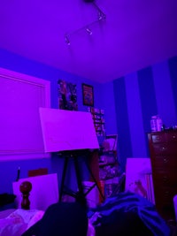 a purple room with a bed and a desk